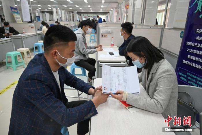 4月14日，招聘者在查看求職者簡(jiǎn)歷。<a target='_blank'  data-cke-saved- >中新社</a>記者 王剛 攝