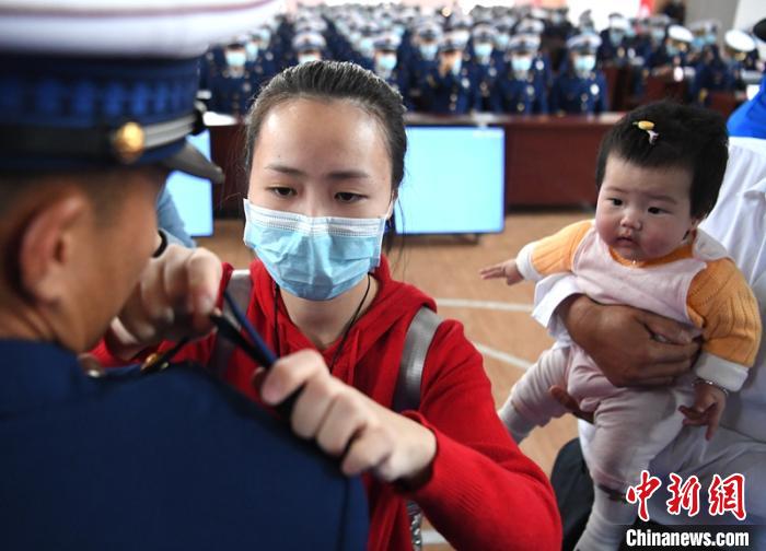 新消防員楊振的妻子彭莉與女兒現(xiàn)場見證丈夫加入“火焰藍(lán)”的神圣時刻。　劉忠俊 攝