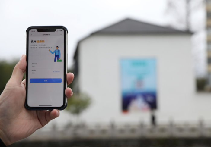 在浙江省杭州市臨安區(qū)天目山鎮(zhèn)，一名居民在“杭州健康碼”海報(bào)上掃碼申領(lǐng)個(gè)人二維碼。新華社發(fā)