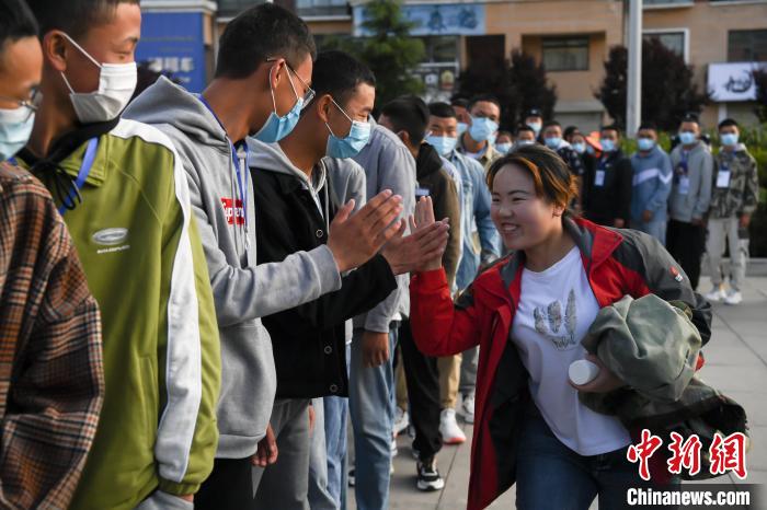 7月7日，拉薩三高考點(diǎn)外，領(lǐng)隊(duì)老師與考生擊掌鼓勁加油?！『闻罾?攝