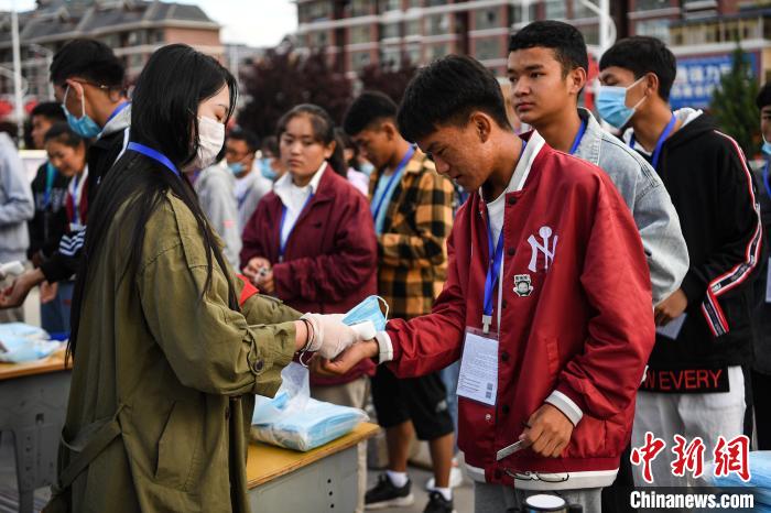 7月7日，考生在拉薩三高考點(diǎn)外測(cè)量體溫?！『闻罾?攝