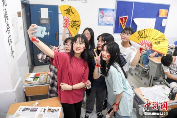 資料圖：6月6日，2021年高考前夕，湖南長沙同升湖實(shí)驗(yàn)學(xué)校高三年級，考生們在教室內(nèi)合影。 楊華峰 攝